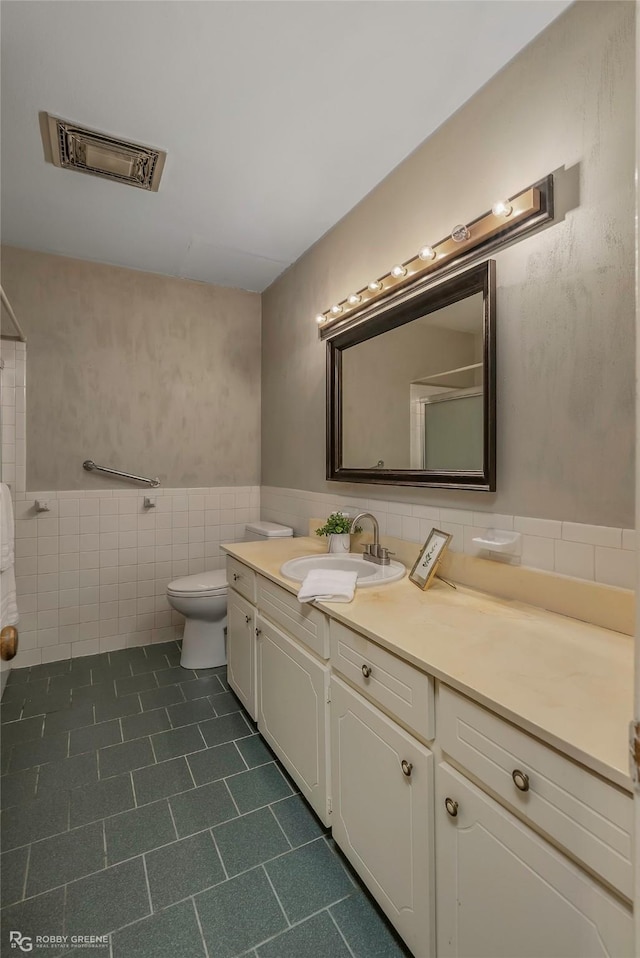 3820 Fairfield Ave Unit 113, Shreveport, LA 71104 - full bathroom with tile walls, vanity, toilet, tile patterned floors, and wainscoting