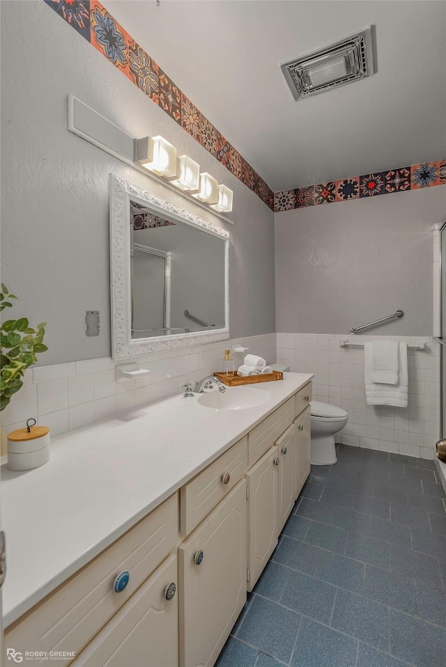 3820 Fairfield Ave Unit 113, Shreveport, LA 71104 - bathroom featuring tile walls, vanity, a shower with door, toilet, and tile patterned floors
