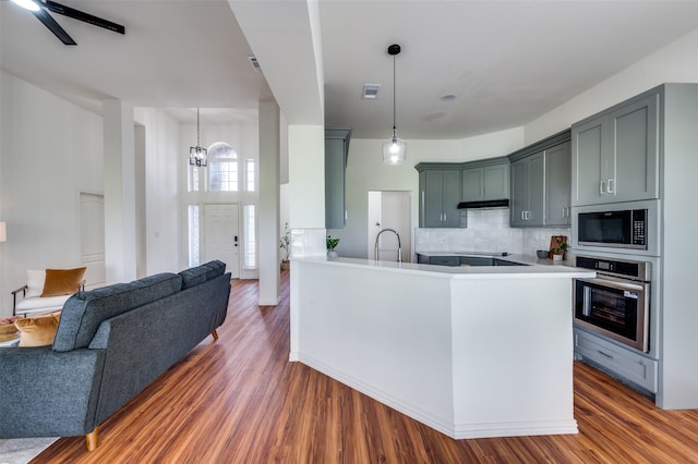212 Cory Ct, Krum, TX 76249 - kitchen with stainless steel appliances, open floor plan, tasteful backsplash, and wood finished floors