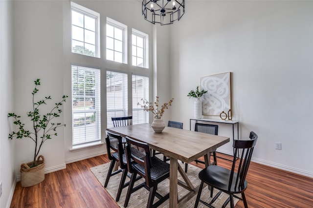212 Cory Ct, Krum, TX 76249 - dining room featuring healthy amount of natural light, a chandelier, baseboards, dark wood-style floors, and a towering ceiling