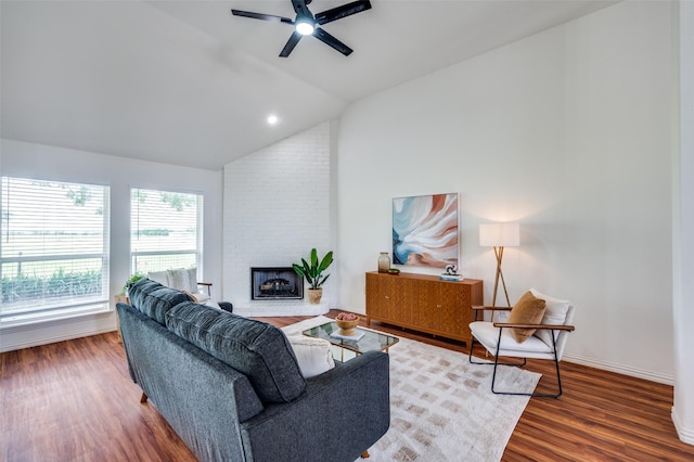 212 Cory Ct, Krum, TX 76249 - living room with vaulted ceiling, a ceiling fan, wood finished floors, a brick fireplace, and baseboards