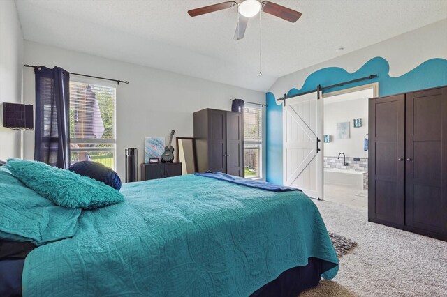 4408 Sunny Oak Ln, Corinth, TX 76208 - bedroom featuring a barn door, carpet flooring, ensuite bath, a ceiling fan, and vaulted ceiling