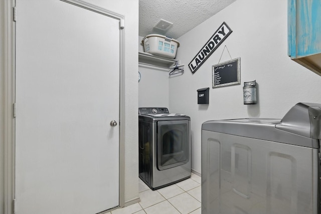 4408 Sunny Oak Ln, Corinth, TX 76208 - laundry room with washer and dryer, a textured ceiling, and light tile patterned flooring