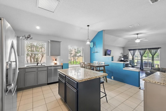 4408 Sunny Oak Ln, Corinth, TX 76208 - kitchen featuring appliances with stainless steel finishes, a sink, a kitchen bar, a center island, and lofted ceiling