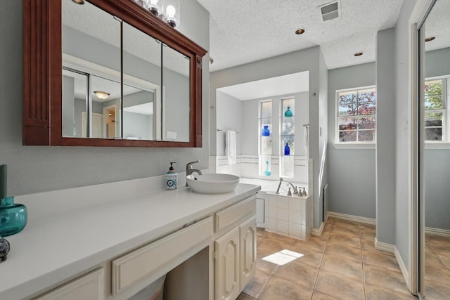 2739 Timberleaf Dr, Carrollton, TX 75006 - bathroom featuring vanity, tile patterned flooring, baseboards, a textured ceiling, and a bath