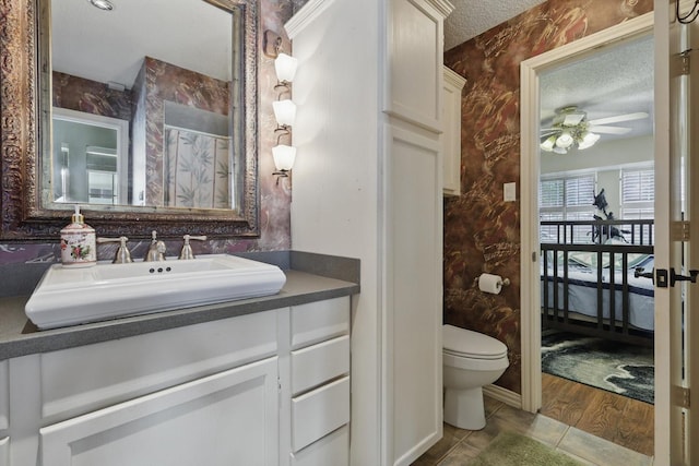 2739 Timberleaf Dr, Carrollton, TX 75006 - full bathroom featuring toilet, vanity, a ceiling fan, a textured ceiling, and tile patterned flooring