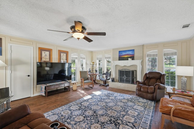 2739 Timberleaf Dr, Carrollton, TX 75006 - living room with ceiling fan, wood finished floors, a textured ceiling, a decorative wall, and a brick fireplace