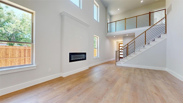 6857 Rutland Dr, Arlington, TX 76002 - unfurnished living room featuring baseboards, wood finished floors, stairs, heating unit, and recessed lighting