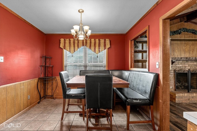 2020 Venus Dr, Bossier City, LA 71112 - dining area featuring a chandelier, ornamental molding, wood walls, a fireplace, and tile patterned floors