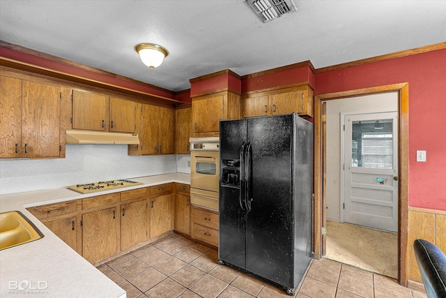 2020 Venus Dr, Bossier City, LA 71112 - kitchen featuring black fridge with ice dispenser, oven, white gas cooktop, under cabinet range hood, and a warming drawer