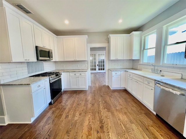 714 Beacon, Dallas, TX 75214 - kitchen with stainless steel appliances, a sink, decorative backsplash, wood finished floors, and recessed lighting
