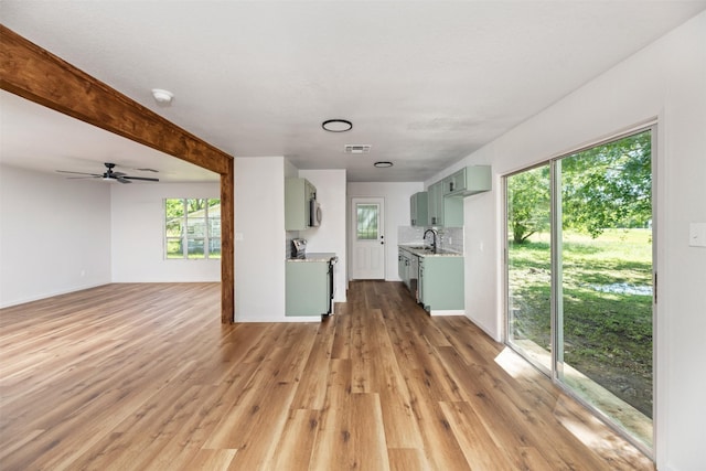 103 Ivy St, Kerens, TX 75144 - unfurnished living room featuring light wood finished floors, a ceiling fan, a sink, and baseboards