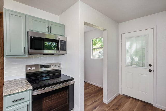 103 Ivy St, Kerens, TX 75144 - kitchen featuring stainless steel appliances, dark wood finished floors, decorative backsplash, green cabinets, and baseboards