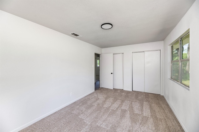 103 Ivy St, Kerens, TX 75144 - unfurnished bedroom featuring multiple closets, carpet, and baseboards