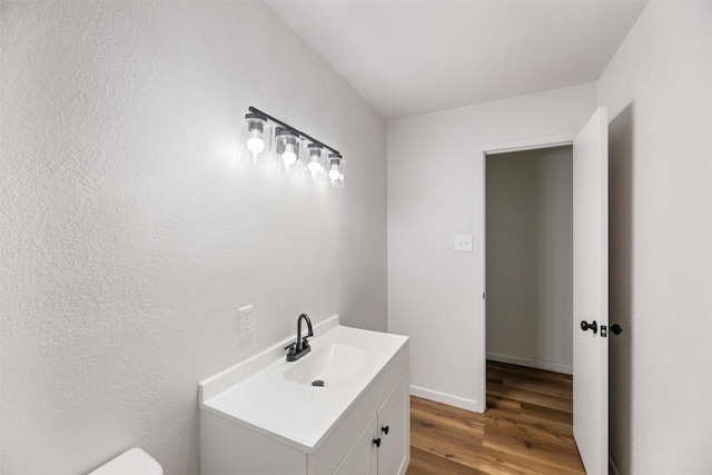 103 Ivy St, Kerens, TX 75144 - half bath with wood finished floors, vanity, toilet, and baseboards