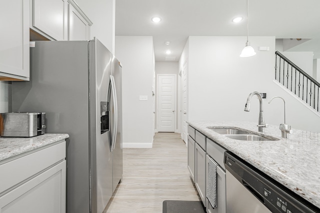 1302 Canyon Creek Rd, Wylie, TX 75098 - kitchen with a sink, stainless steel appliances, light wood-type flooring, light stone countertops, and recessed lighting