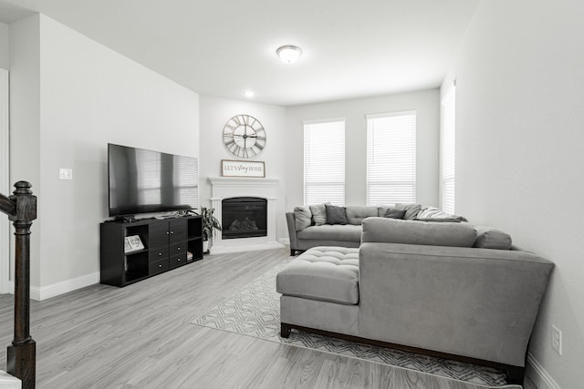1302 Canyon Creek Rd, Wylie, TX 75098 - living room with wood finished floors, baseboards, and a glass covered fireplace