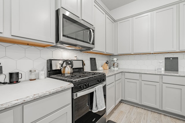 1302 Canyon Creek Rd, Wylie, TX 75098 - kitchen with stainless steel appliances, tasteful backsplash, and light stone counters
