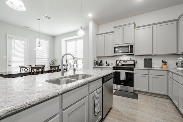 1302 Canyon Creek Rd, Wylie, TX 75098 - kitchen with stainless steel appliances, a sink, backsplash, light stone counters, and recessed lighting
