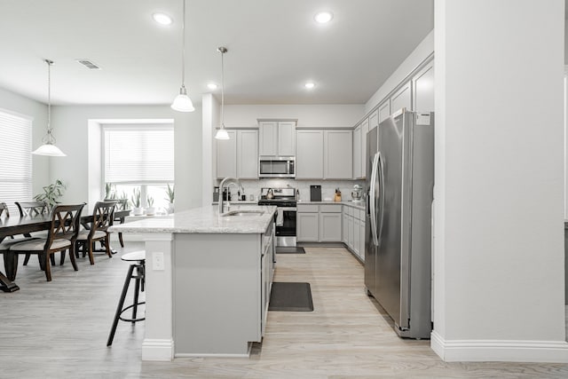 1302 Canyon Creek Rd, Wylie, TX 75098 - kitchen featuring stainless steel appliances, a sink, light wood-style flooring, an island with sink, and recessed lighting