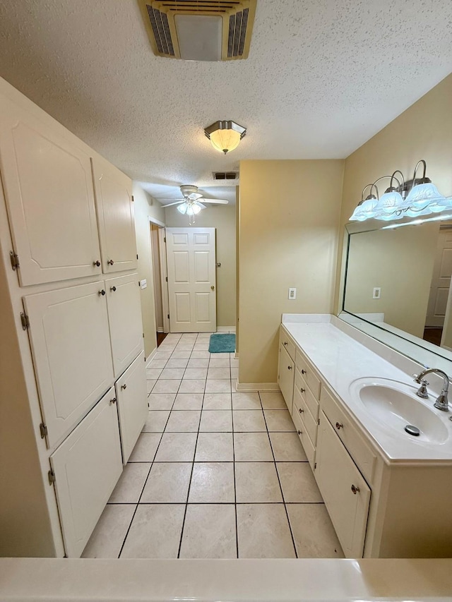 11535 Timber Ridge Dr, Keithville, LA 71047 - bathroom with tile patterned flooring, a textured ceiling, a ceiling fan, vanity, and baseboards