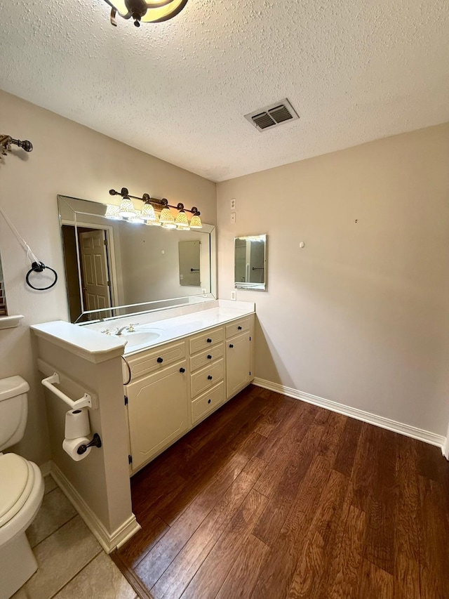 11535 Timber Ridge Dr, Keithville, LA 71047 - bathroom featuring toilet, wood finished floors, vanity, a textured ceiling, and baseboards