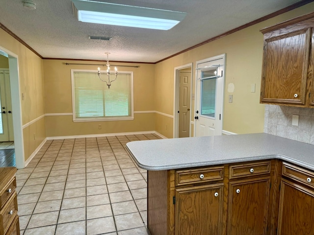 11535 Timber Ridge Dr, Keithville, LA 71047 - kitchen with a peninsula, a chandelier, light countertops, ornamental molding, and a textured ceiling