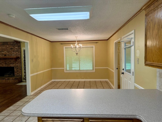 11535 Timber Ridge Dr, Keithville, LA 71047 - unfurnished dining area with light tile patterned floors, a textured ceiling, crown molding, a chandelier, and a brick fireplace