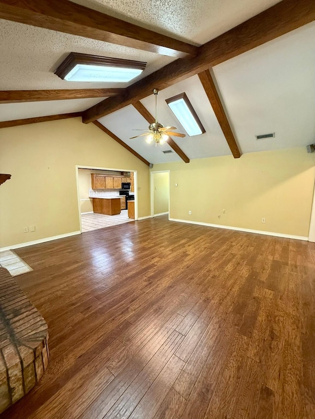 11535 Timber Ridge Dr, Keithville, LA 71047 - unfurnished living room with a skylight, wood-type flooring, ceiling fan, baseboards, and a textured ceiling