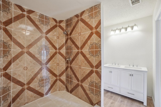 12848 Hilltop Dr, Balch Springs, TX 75180 - full bathroom with wood finished floors, a tile shower, and double vanity