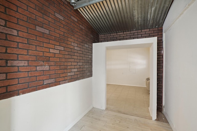 12848 Hilltop Dr, Balch Springs, TX 75180 - corridor featuring brick wall, lofted ceiling, baseboards, and light wood-type flooring