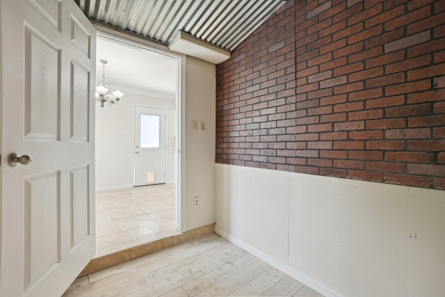 12848 Hilltop Dr, Balch Springs, TX 75180 - hall with a chandelier, brick wall, and wood finished floors