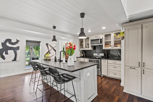 313 Chicken St, Weston, TX 75009 - kitchen featuring appliances with stainless steel finishes, dark countertops, a breakfast bar, glass insert cabinets, and recessed lighting
