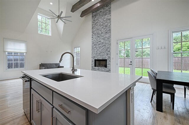 5067 Gaston Ave, Dallas, TX 75214 - kitchen with gray cabinets, a sink, open floor plan, high vaulted ceiling, and light wood finished floors