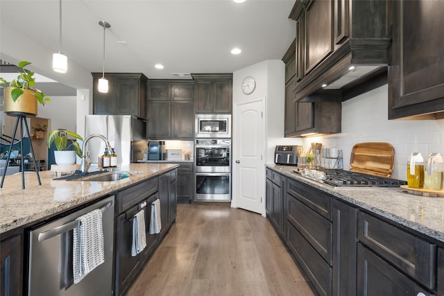 205 Big Creek Loop, Hewitt, TX 76643 - kitchen with stainless steel appliances, a sink, dark brown cabinetry, tasteful backsplash, and light stone counters