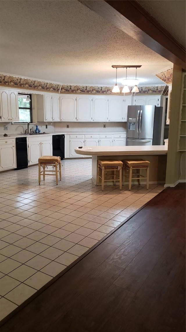 401 S Timberlane, Lone Star, TX 75638 - kitchen featuring stainless steel refrigerator with ice dispenser, white cabinets, dishwasher, a textured ceiling, and light countertops