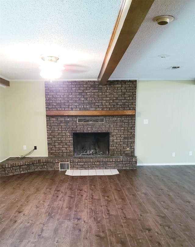 401 S Timberlane, Lone Star, TX 75638 - unfurnished living room featuring a textured ceiling, wood finished floors, and a brick fireplace