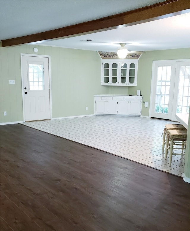 401 S Timberlane, Lone Star, TX 75638 - unfurnished living room featuring beam ceiling, baseboards, and dark wood-style floors