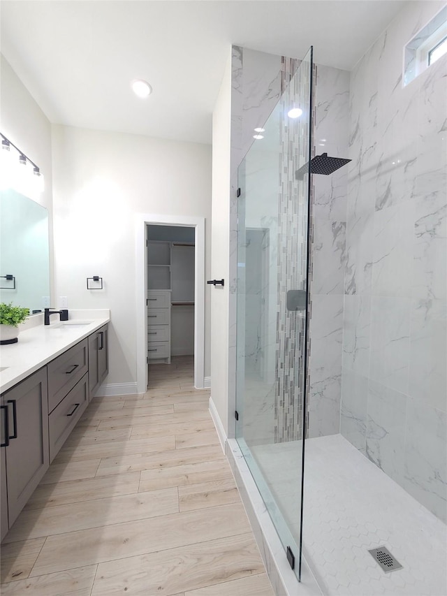 1506 Sayle St, Greenville, TX 75401 - full bath featuring vanity, a marble finish shower, a spacious closet, wood finished floors, and recessed lighting