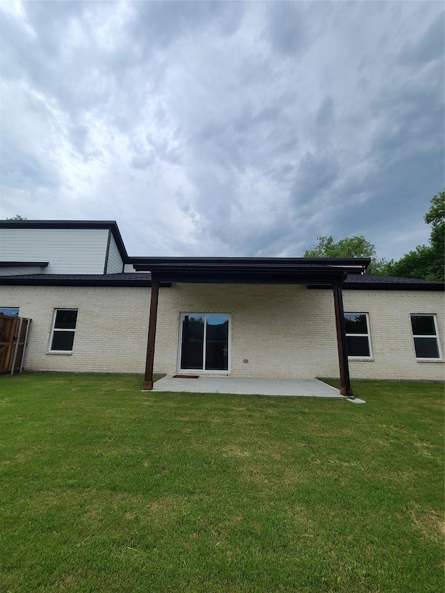 1506 Sayle St, Greenville, TX 75401 - back of house featuring a patio, a yard, and brick siding
