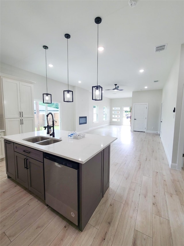 1506 Sayle St, Greenville, TX 75401 - kitchen with dishwasher, a sink, light wood-style floors, light countertops, and plenty of natural light