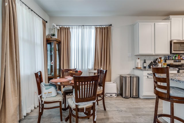 5725 Miriam Dr, Forney, TX 75126 - dining space featuring light wood-style floors and a bar