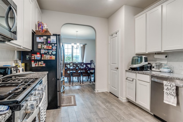 5725 Miriam Dr, Forney, TX 75126 - kitchen with stainless steel appliances, a chandelier, light wood-style floors, arched walkways, and white cabinetry
