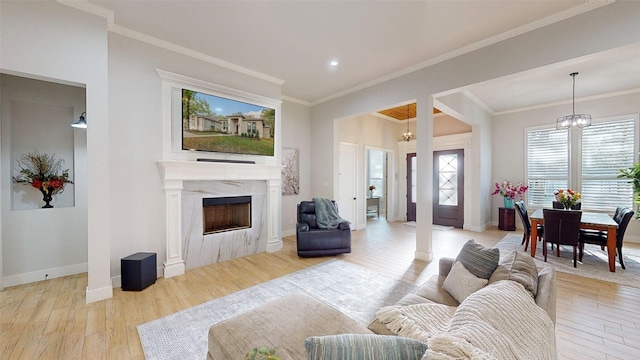 126 Saint Andrews Dr E, Mabank, TX 75156 - living area with light wood-type flooring, a chandelier, a high end fireplace, baseboards, and ornamental molding