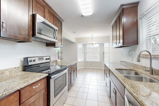 6432 Melinda Ct, Watauga, TX 76148 - kitchen with stainless steel appliances, a sink, light tile patterned floors, a chandelier, and plenty of natural light