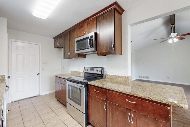 6432 Melinda Ct, Watauga, TX 76148 - kitchen featuring stainless steel appliances, a ceiling fan, baseboards, light stone countertops, and a peninsula