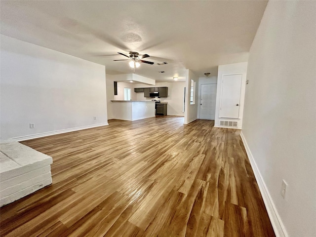 3913 Longstraw Dr, Fort Worth, TX 76137 - unfurnished living room featuring ceiling fan, wood finished floors, and baseboards