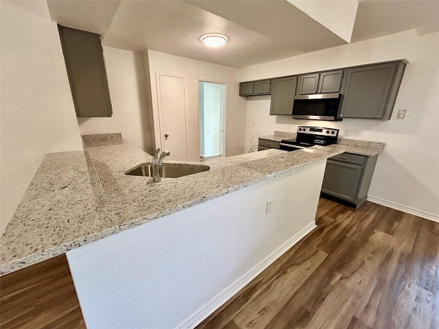 3913 Longstraw Dr, Fort Worth, TX 76137 - kitchen featuring appliances with stainless steel finishes, a sink, light stone countertops, a peninsula, and dark wood-type flooring