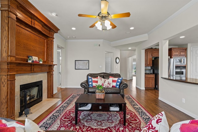2505 Shoreline Dr, Keller, TX 76248 - living area featuring dark wood-style flooring, ornamental molding, a ceiling fan, a tiled fireplace, and baseboards