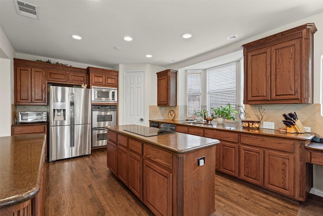 2505 Shoreline Dr, Keller, TX 76248 - kitchen featuring appliances with stainless steel finishes, a sink, a center island, tasteful backsplash, and dark wood-style flooring
